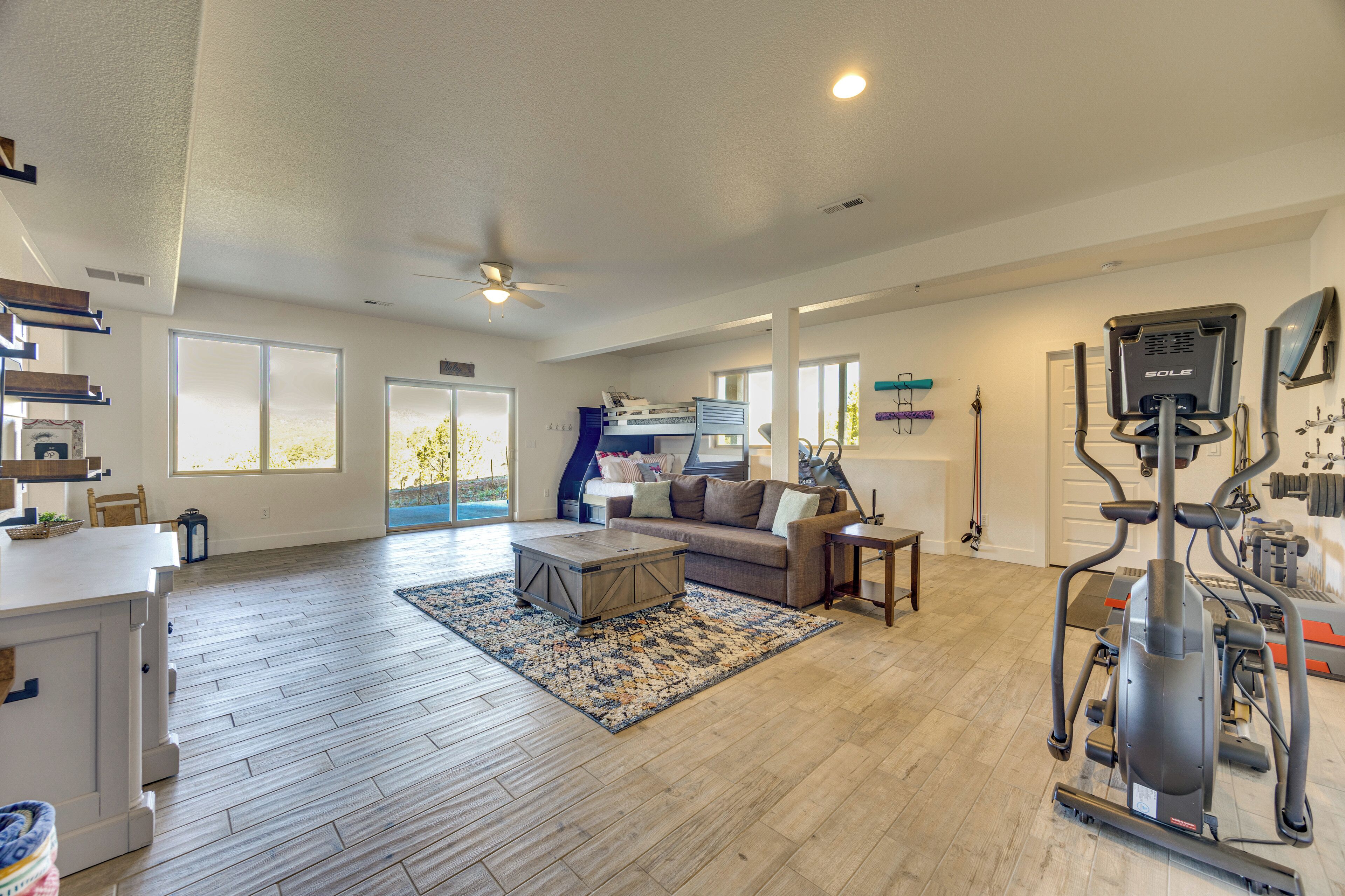 A spacious living area with a couch, coffee table, and exercise equipment.