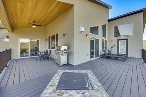 A covered outdoor deck with a grill, seating, and a view of the landscape. - 200-acre Mtn Getaway Near the Arkansas River (Canon City)