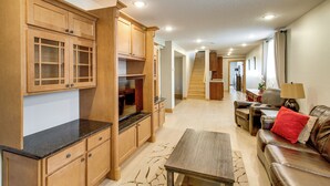 A spacious living area with wooden cabinets, a dining table, and a leather sofa. - 40-acre Brook Park Retreat Near Lakes & Fishing! (Brook Park)
