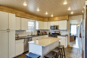 A kitchen with white cabinets, a central island, stainless steel appliances, and a wooden ceiling. - 40-acre Brook Park Retreat Near Lakes & Fishing! (Brook Park)