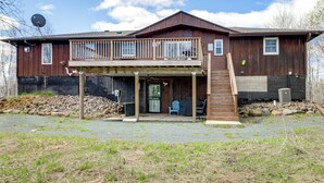 A two-story wooden house with a balcony, a front door, and a small porch area. - 40-acre Brook Park Retreat Near Lakes & Fishing! (Brook Park)
