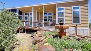 A two-story building with a covered porch, a wooden bridge, and a rock garden. - Chiricahua Birding Cabin By Cave Creek Canyon! (San Simon)