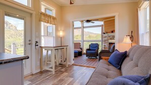 A spacious living area with a sofa, a dining table, and a ceiling fan. - Chiricahua Birding Cabin By Cave Creek Canyon! (San Simon)