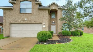 A two-story house with a garage, a front door, and a small porch. - Private Yard & Furnished Patio! Rosenberg Retreat (Richmond)