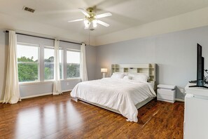 A bedroom with a bed, a desk, a chair, a ceiling fan, and a window with curtains. - Private Yard & Furnished Patio! Rosenberg Retreat (Richmond)