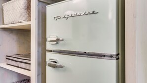 Un refrigerador Frigidaire blanco con dos puertas, un estante superior y uno inferior.