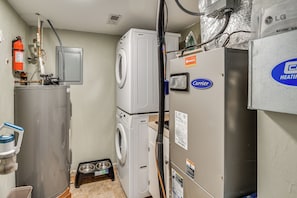A laundry room with a washer, dryer, and water heater.