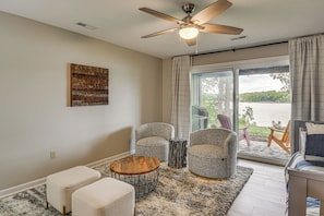 A room with a ceiling fan, a large window with curtains, two armchairs, a small round table, and a bed with a view of a lake. - Swim Dock Access! Moneta Escape, 5 Mi to Boat Ramp (Moneta)