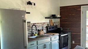 A modern kitchen with a refrigerator, stove, and sink.