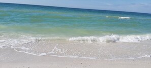 A beach with clear turquoise water and gentle waves. - 🌞Beach Across the Street🌴Pool/Fishing Dock/Grills🐬Barefoot Beach Resort A105 (Indian Shores)