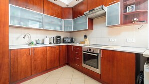 Cocina con gabinetes de madera, horno de acero inoxidable y microondas.