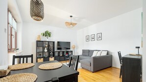 Una sala de estar moderna con una mesa de comedor, sofá y televisor.