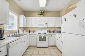 A kitchen with white cabinets, a microwave, stove, and refrigerator. - Ironwood #1433 New on Program! Great Location and Lots of Amenities! (North Myrtle Beach)