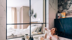 A bathtub filled with bubbles, a glass of wine, and toiletries on a tray. - Love Story Studio with Jacuzzi Sopot (Sopot)
