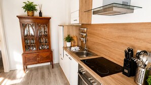 Une cuisine moderne dotée d’un plan de travail en bois, d’appareils électroménagers en acier inoxydable et d’un four encastré.