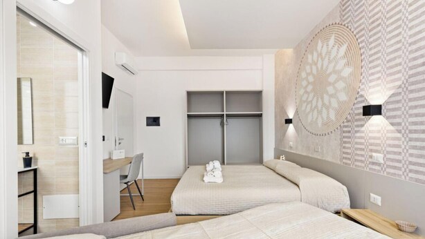 A modern bedroom with two beds, a desk, and a wardrobe. - Essentia Boutique Rooms 104 – Extra comfort and flexibility in central Cagliari ✨ (Cagliari)