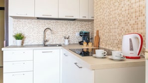 Een keuken met een spoelbak, een koffiezetapparaat, een broodrooster en een plant.