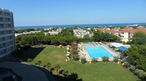 Ein Hotel mit Schwimmbad, Rasen und Meerblick.