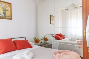 Ein Hotelzimmer mit einem Bett, einem Nachttisch, einem Spiegel und einem Fenster mit Vorhängen.