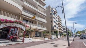 Un hotel de diverses plantes amb balcons, un restaurant a la planta baixa i un cel serè.