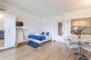 A modern bedroom with a bed, bedside table, and a small seating area. - Apartment on the Croisette in Cannes (Cannes)