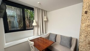 A corner room with a window, a table, a sofa, and two lamps. - Oporto Riverside Apartments (Porto)