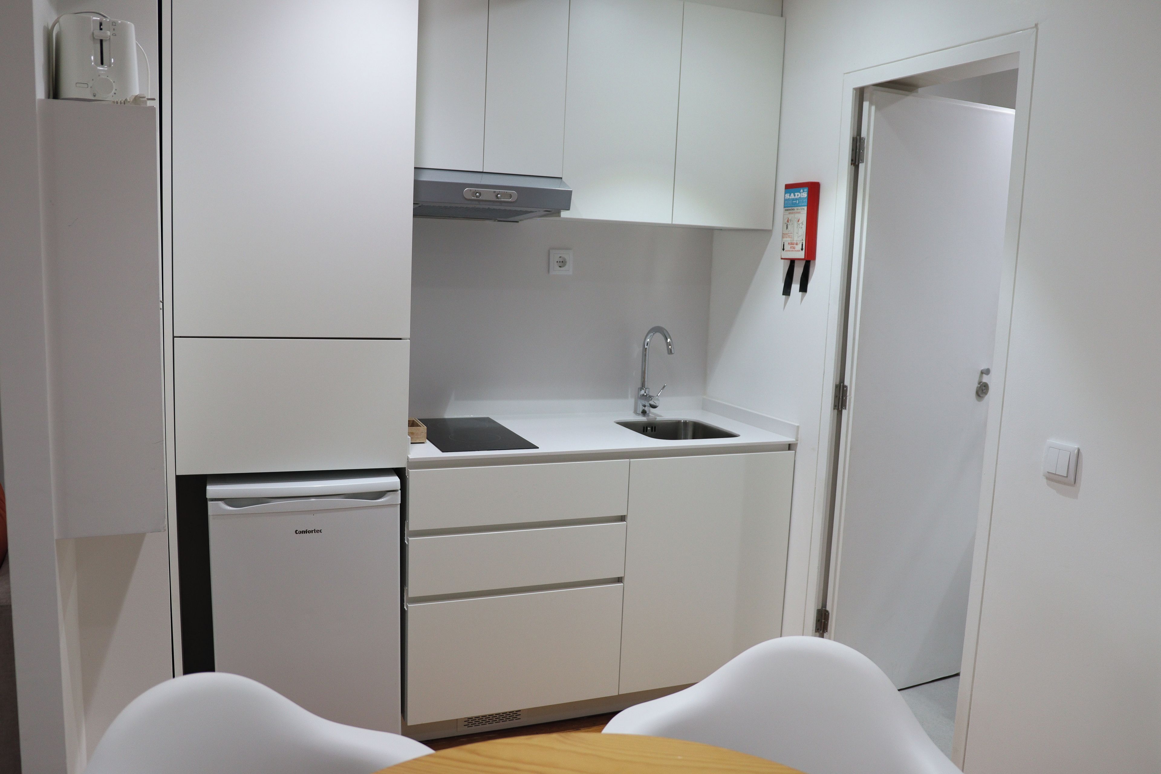 A compact kitchenette with a built-in dishwasher, a sink, and a small countertop.