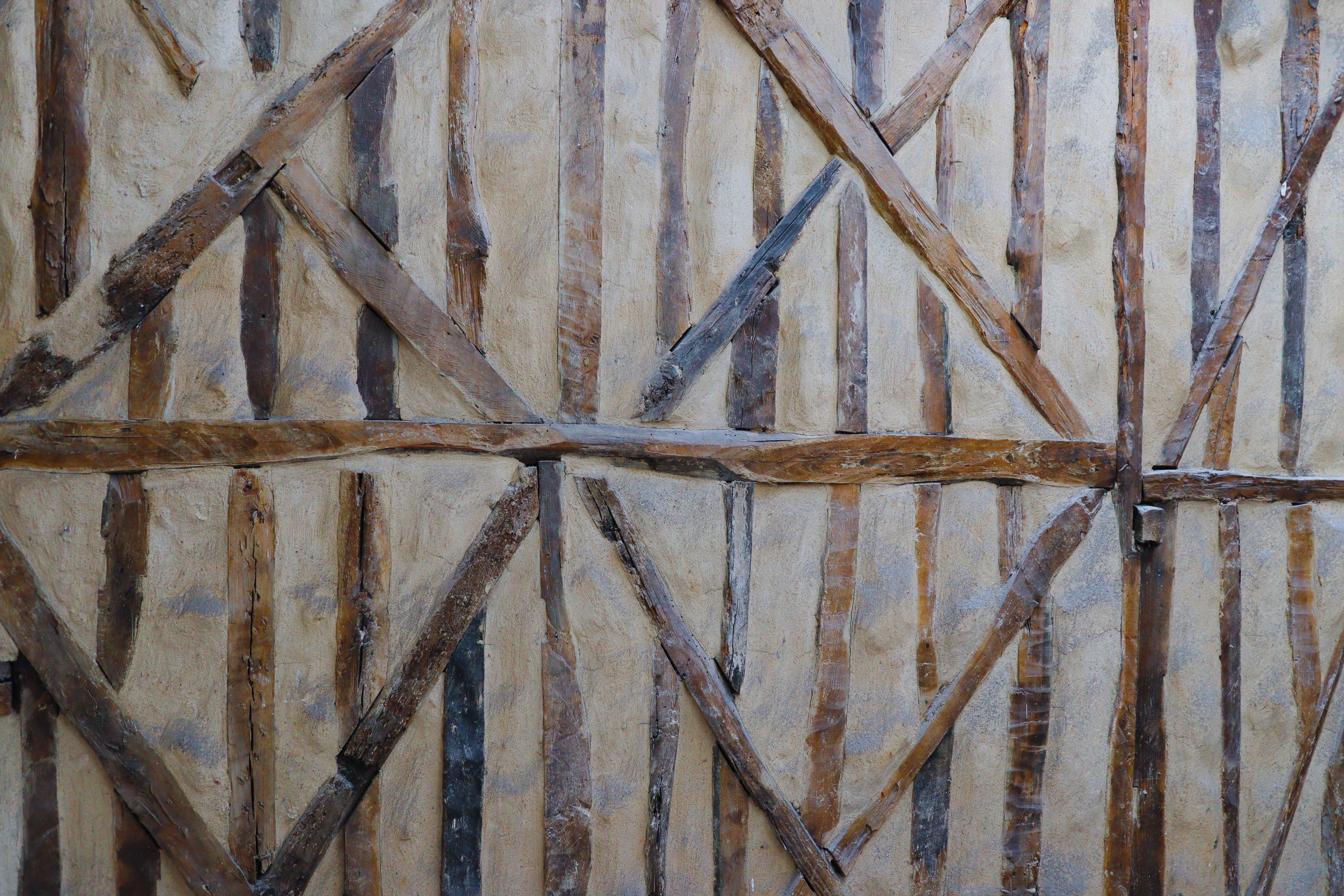 A wall with a crisscross pattern of wooden beams.