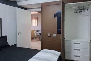 Ein Schlafzimmer mit einem Bett, einem Kleiderschrank und einem Schreibtisch mit Stuhl.