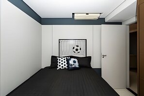 Een slaapkamer met een bed, een wandairconditioner, een deur en een kledingkast.