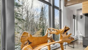 Un interior moderno con un ventanal grande, un banco de madera y un diseño minimalista.