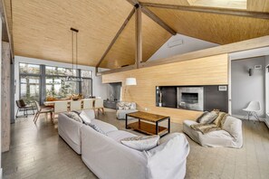 A spacious living area with a large sofa, a coffee table, and a fireplace. - Le Refuge Montagnard (Petite-Rivière-Saint-François)
