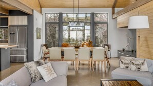 Una cocina moderna con refrigerador, mesa y sillas.