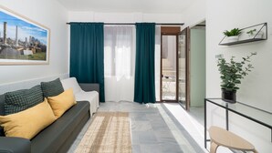 A modern living room with a sofa, a coffee table, and a view of the outside. - Exarchia - Apartment for 4 pax (Athina)