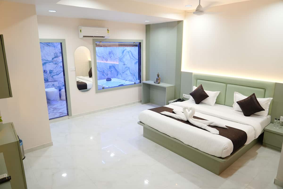 Une chambre d’hôtel moderne, dotée d’un grand lit, d’une table de chevet, d’un miroir et d’une fenêtre offrant une vue agréable.