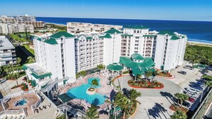 A resort with multiple buildings, a central pool, and a view of the ocean. - Resort on Cocoa Beach: a 2 bedrooms Ocean View (Cocoa Beach)