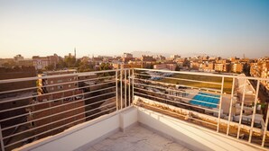 A balcony with a view of a cityscape, including buildings and a swimming pool. - signature house luxor (Luxor)