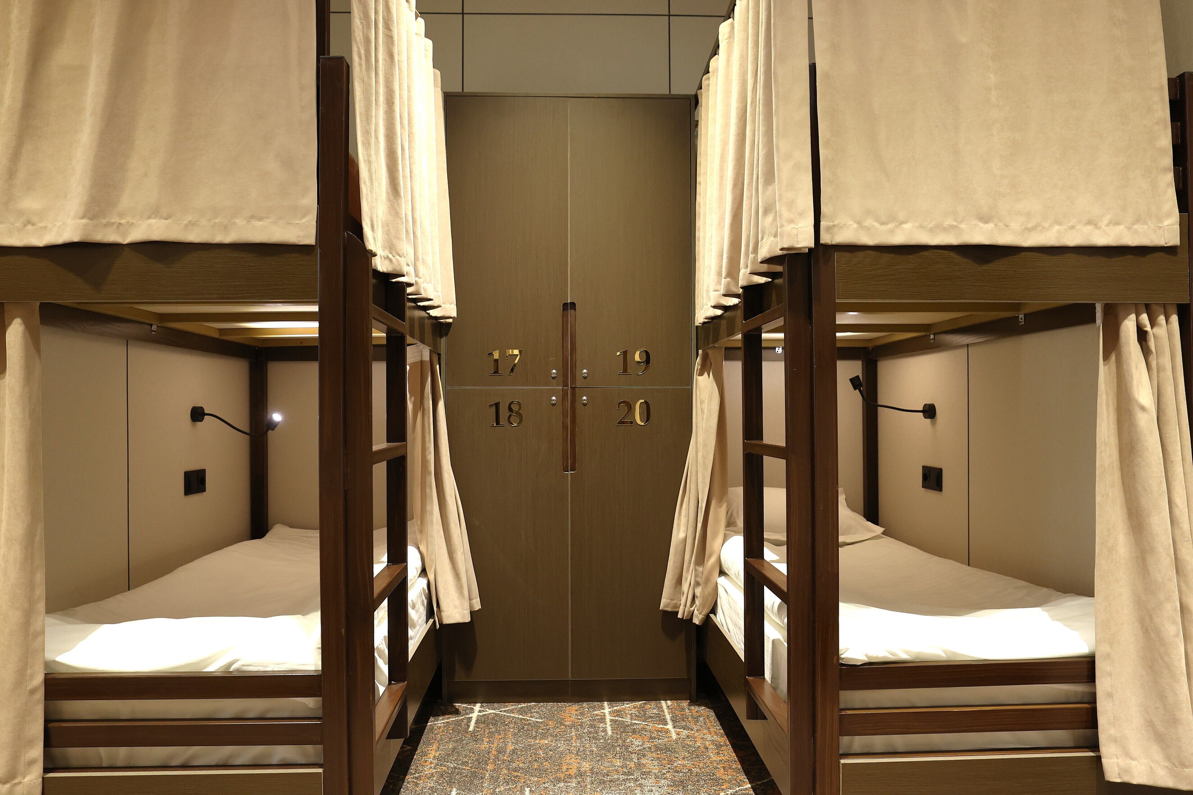 A room with bunk beds, each bed numbered from 17 to 20, and a central door.