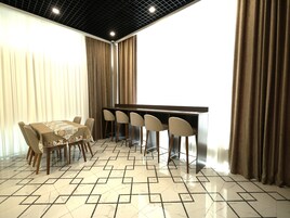 Comedor con una mesa, sillas, un piano y un suelo estampado.