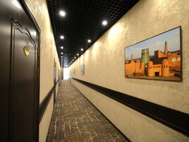 Un pasillo con piso estampado, un reloj en la puerta y un cuadro en la pared.