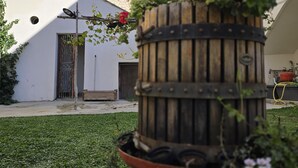 A courtyard with a wooden barrel planter, a white building with a window, and a door. - N haidea - AgriFarm e B&B  (Lettere)