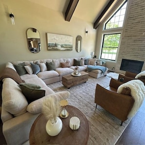 Una sala de estar con un sofá seccional, una mesa de centro y una chimenea.