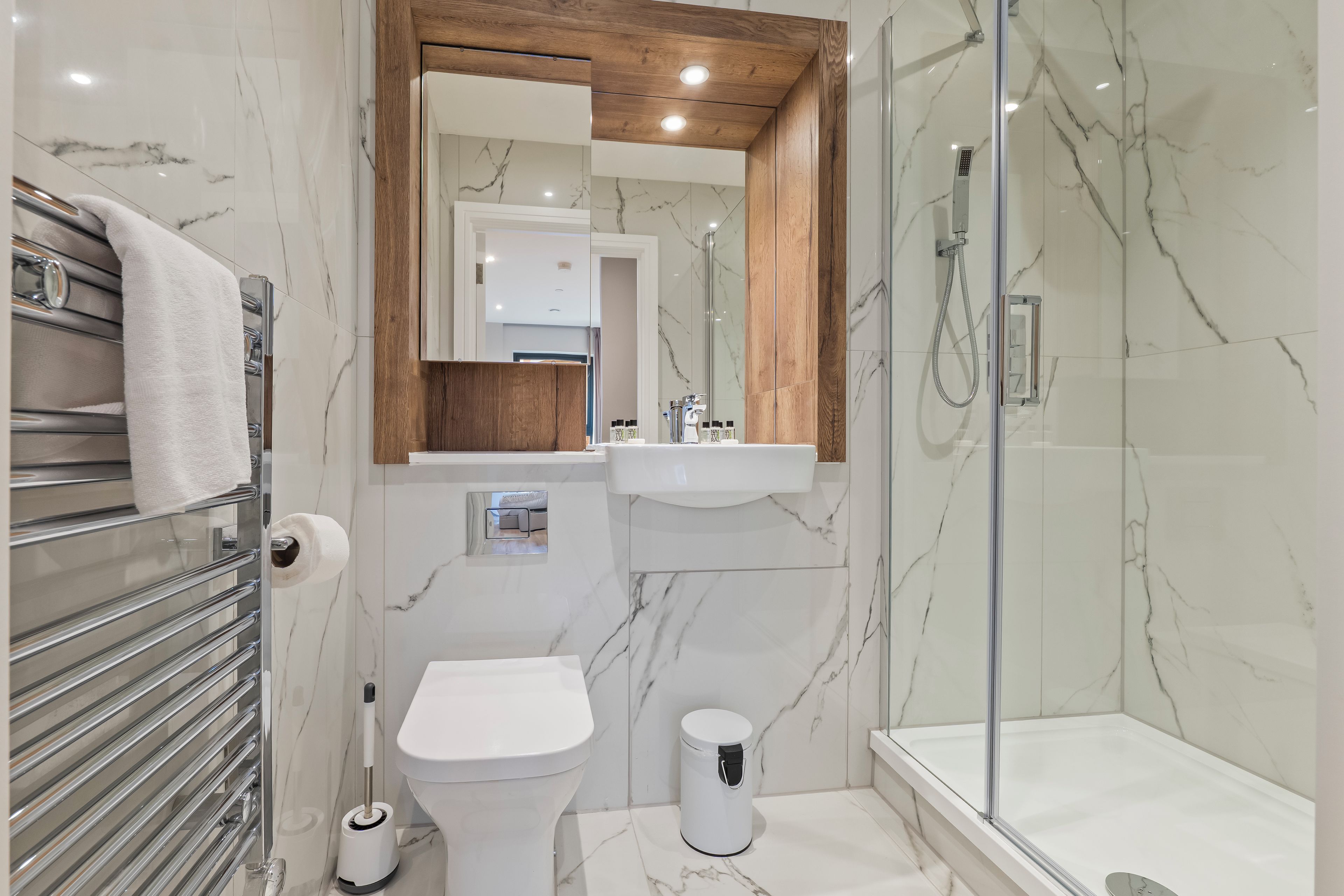 Une salle de bain moderne avec une douche à parois de verre, des toilettes et un lavabo.
