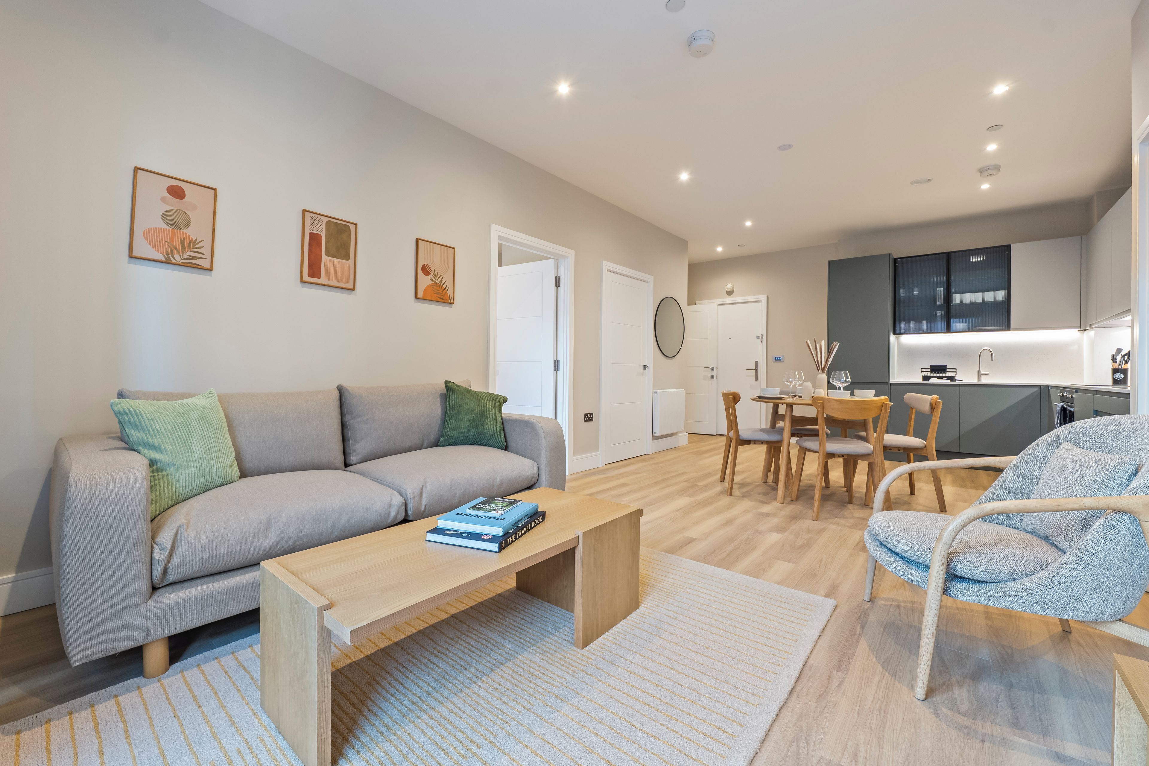 Una sala de estar moderna con sofá, mesa de centro y un comedor con sillas y mesa.