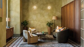 A cozy living room with a sofa, armchair, coffee table, and potted plants. - StayCozy Apartments in Birmingham (Birmingham)