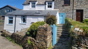 Una casa de piedra con puerta azul, una chimenea y un letrero que dice 'Atlantic View'.