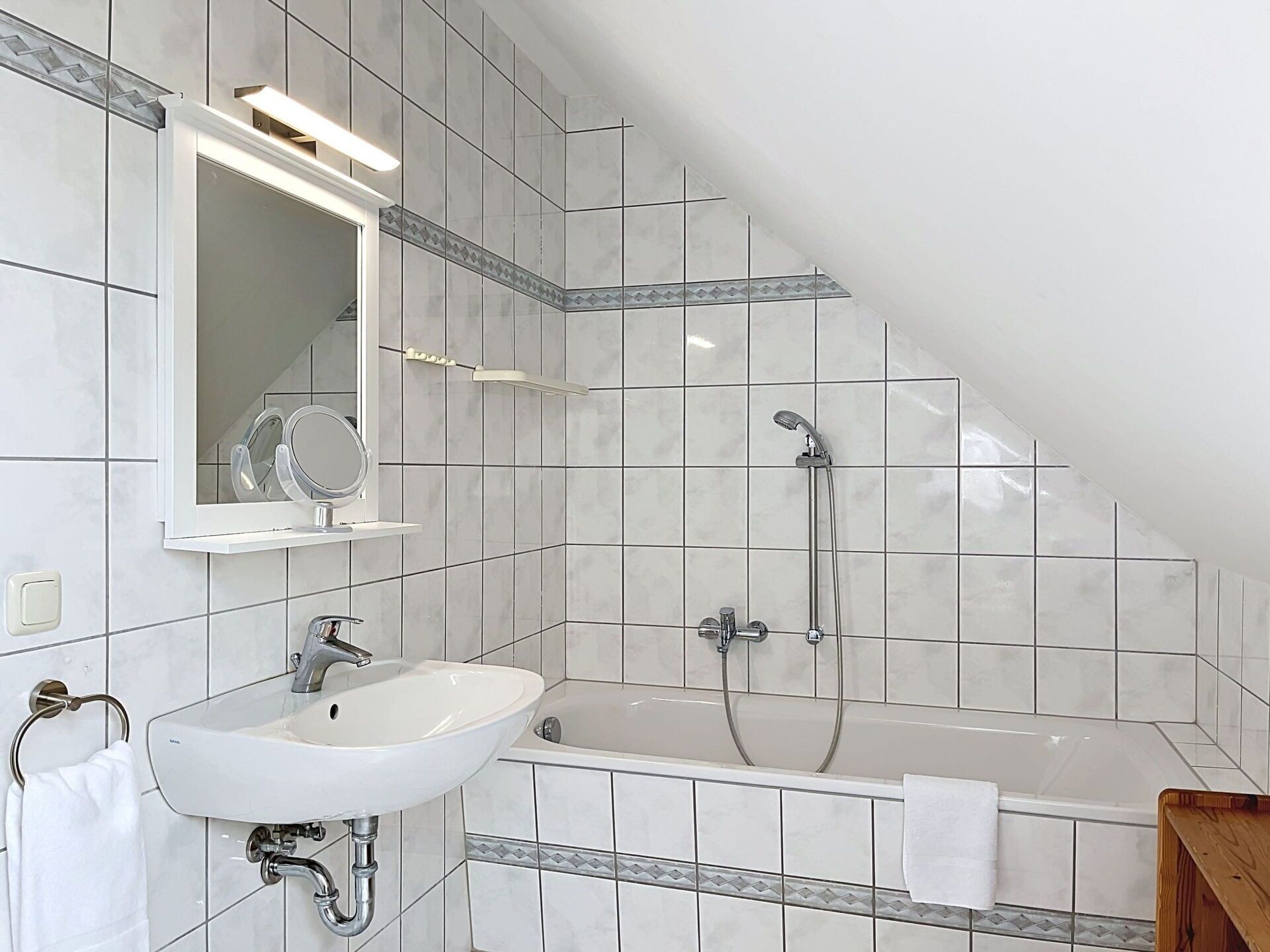 Une salle de bain moderne avec un lavabo blanc, un miroir et une douche.