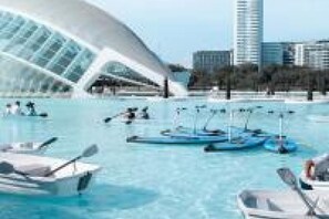A waterfront hotel with a distinctive white building, boats, and a clear blue sky. - Travel Habitat Mediterranean Studio (Valencia)