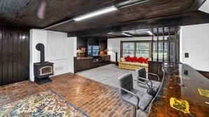 A modern living room with a fireplace, a sofa, a coffee table, and a large window. - Unadilla Riverfront Oasis 3br Sleeps 8 3 Bedroom Home (Unadilla)