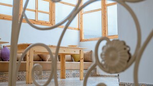 Una habitación con una mesa de madera, un sofá y un suelo estampado.